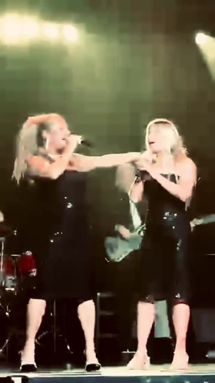 A mother and daughter singing together on stage